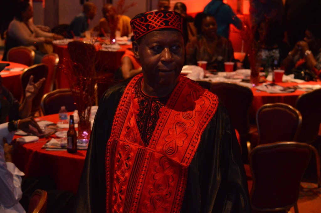 James Credle in traditional African clothing. At the Fireball event, standing in front of cabaret style tables. 