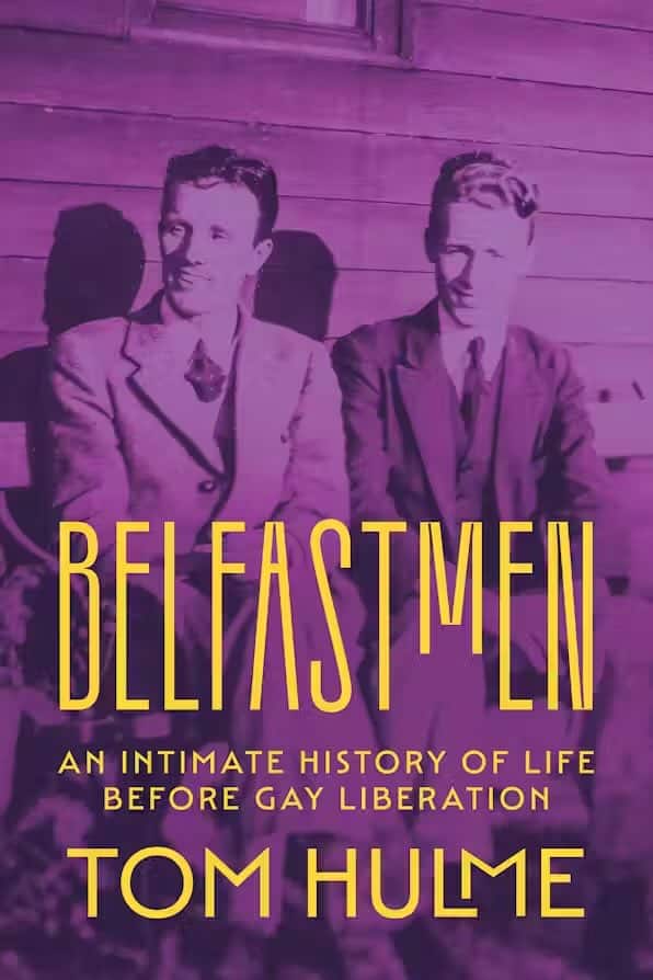 cover of the book, Belfastmen, with yellow text on a purple tinted photo. The photo depicts Lewis and Greeves seated, touching shoulders.